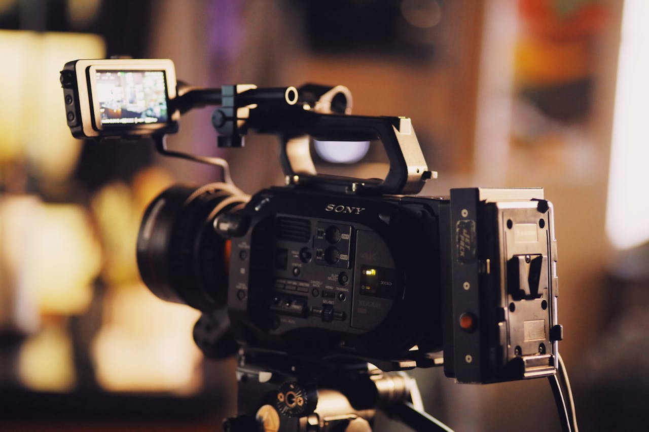Services-02 A modern video camera on a tripod with a small screen, perfect for filmmaking and video production.